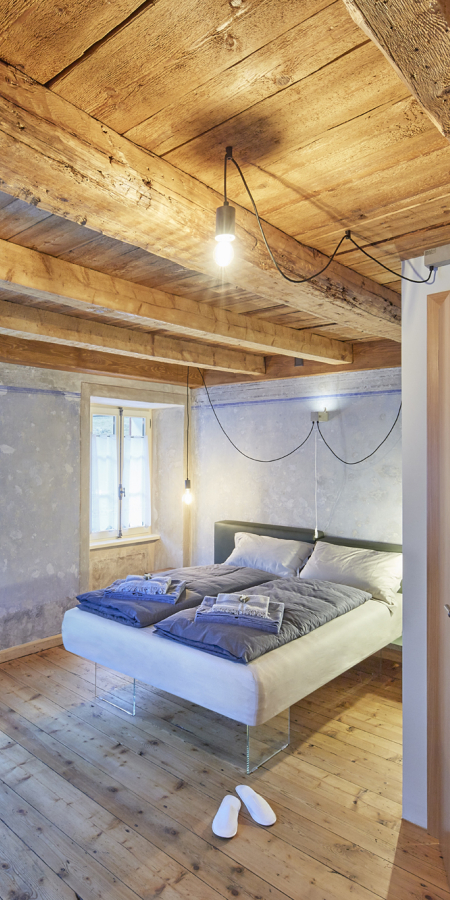 Accogliente camera da letto con travi in legno a vista, letto matrimoniale e bagno moderno adiacente in un BnB