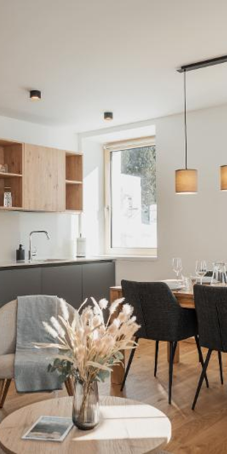 Moderne Ferienwohnung mit offener Küche, Esstisch und stilvoller Beleuchtung in einem hellen Raum