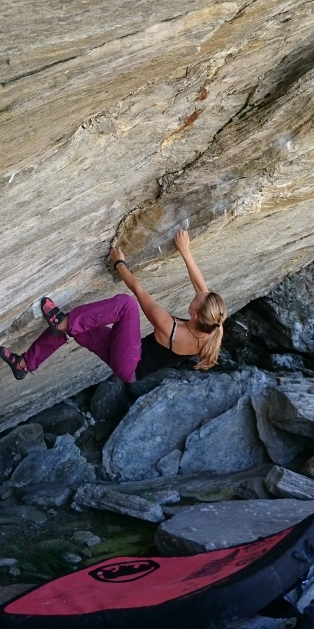 Bouldern am rauen Granit des Calancatals inmitten unberührter Natur Frau beim Bouldern an einer überhängenden Felswand im Calancatal