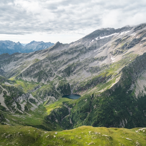 Il laghetto di Trescolmen compare tra le cime appena passato il Fil de Bedoletta