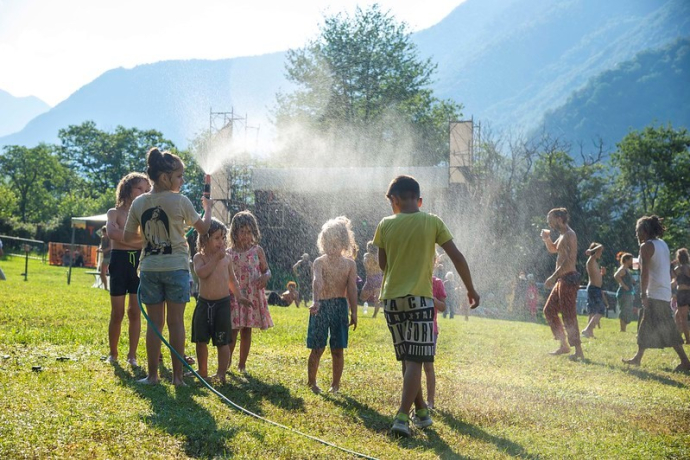 dei bambini giocano con il tubo dell'acqua