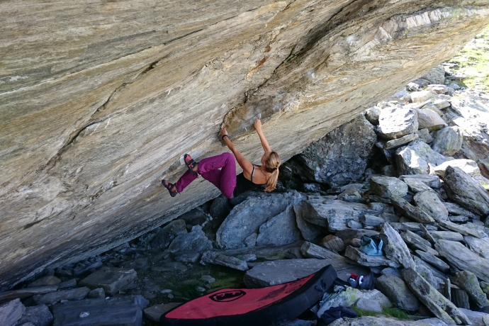 Bouldern am rauen Granit des Calancatals inmitten unberührter Natur Frau beim Bouldern an einer überhängenden Felswand im Calancatal