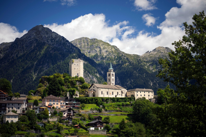 Chiesa e torre del castello di Santa Maria in Val Calanca con sfondo alpino