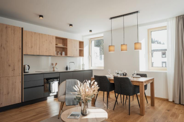 Moderne Ferienwohnung mit offener Küche, Esstisch und stilvoller Beleuchtung in einem hellen Raum